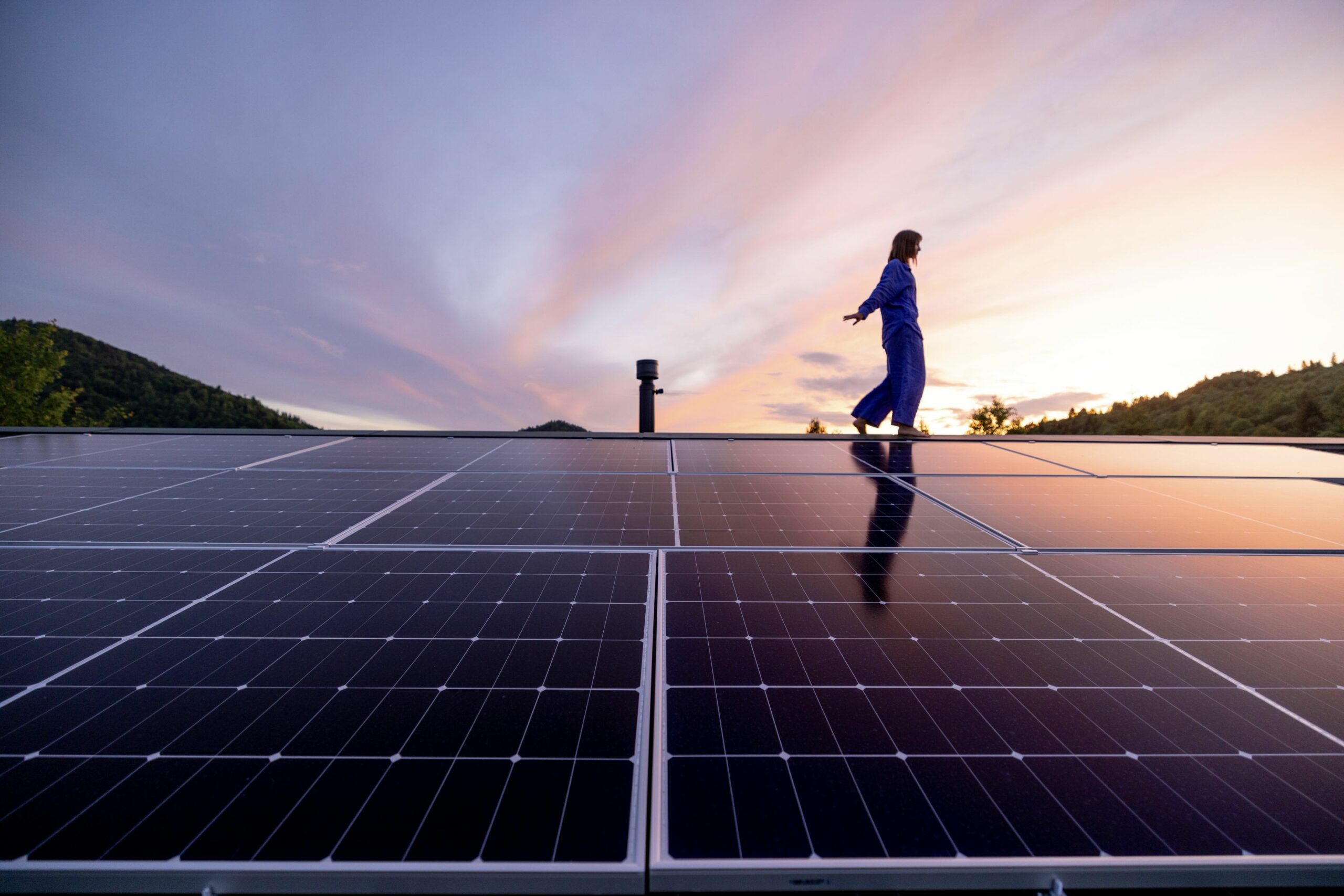 Frau geht auf Dach über Solarpaneele