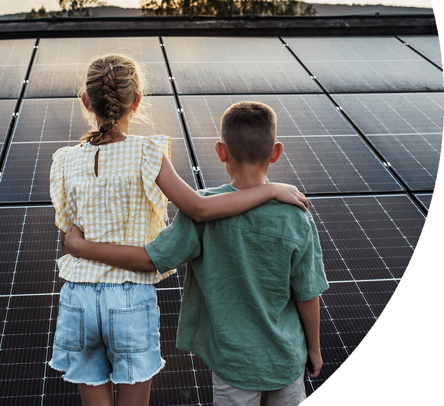 Kinder Arm in Arm vor Solar-Panelen - Nachhaltige Energie aus der Nachbarschaft